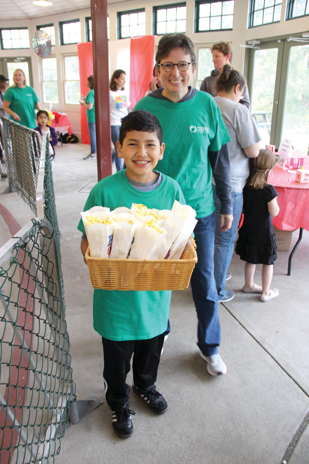 IT WAS A HIT: Cal helps his mom, Lisa Carcieri hand out free popcorn at Saturday’s event. Neighborhood Health Plan of RI is a major sponsor of Reach Out and Read and about 20 NHPRI employees volunteered to help with Saturday’s event.